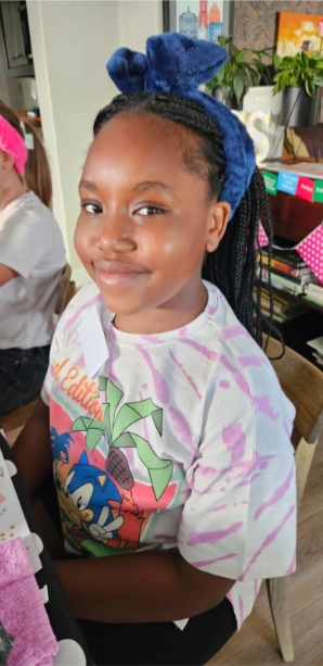 Young black girl smiling while attending Girl-School class.