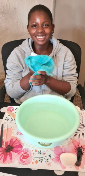 Young black girl washing her face in Girl-School class.