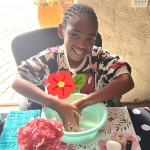 Young black girl washing her hands in Girl-School class.